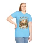 T-Shirt — "Soft Life, Loud Quacks" Cute Duck Graphic Tee one dramatic duck standing in shallow pond water with cattails, ripples, reeds, and a slightly judgmental expression. Give the duck a...