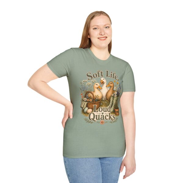 T-Shirt — "Soft Life, Loud Quacks" Cute Duck Graphic Tee one dramatic duck standing in shallow pond water with cattails, ripples, reeds, and a slightly judgmental expression. Give the duck a...