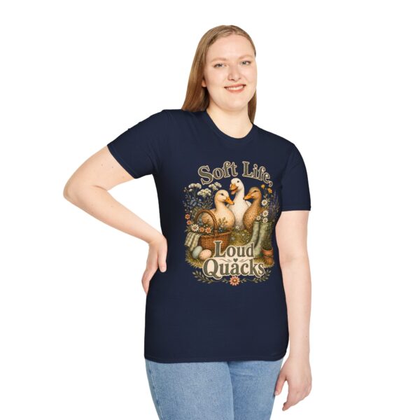 T-Shirt — "Soft Life, Loud Quacks" Cute Duck Graphic Tee one dramatic duck standing in shallow pond water with cattails, ripples, reeds, and a slightly judgmental expression. Give the duck a...
