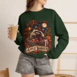 Crewneck Sweatshirt — "The Apple Bobber" Halloween Raccoon Apple-Bobbing Design